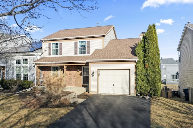 traditional-style house featuring a garage, covered porch, brick siding, a shingled roof, and driveway