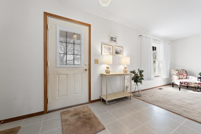 carpeted entryway with plenty of natural light and baseboards