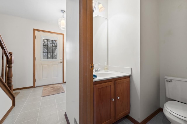 half bathroom with baseboards, vanity, toilet, and tile patterned floors