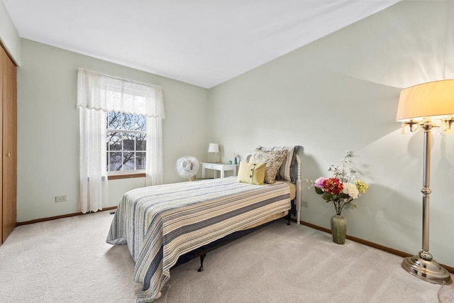 bedroom featuring baseboards and light colored carpet