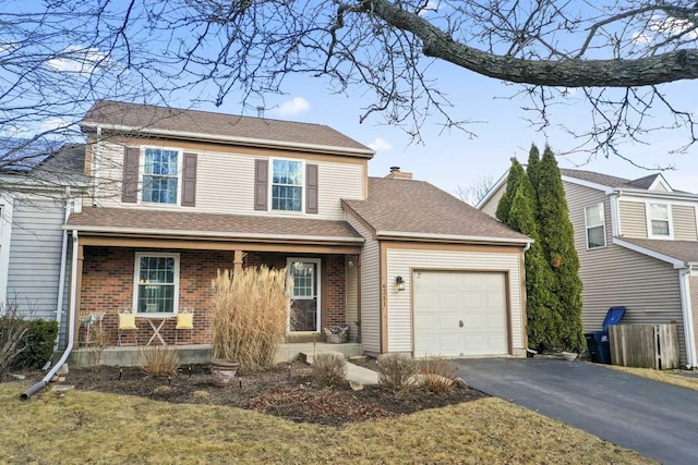 traditional-style house featuring driveway, a shingled roof, a chimney, an attached garage, and brick siding