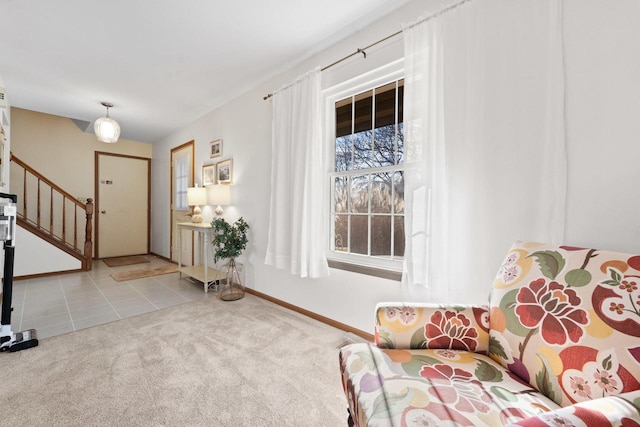 tiled entrance foyer featuring carpet floors, baseboards, and stairway