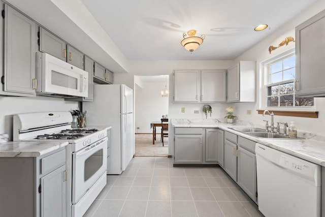 kitchen with gray cabinets, white appliances, a sink, and light tile patterned floors