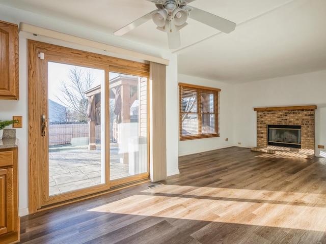 doorway to outside featuring a fireplace, hardwood / wood-style flooring, and ceiling fan