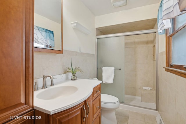 bathroom with walk in shower, vanity, toilet, and tile walls