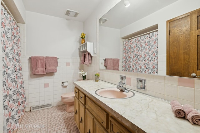 bathroom featuring tile walls, vanity, tile patterned floors, and toilet