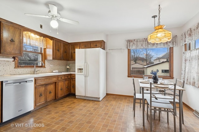 kitchen featuring hanging light fixtures, tasteful backsplash, white fridge with ice dispenser, and stainless steel dishwasher