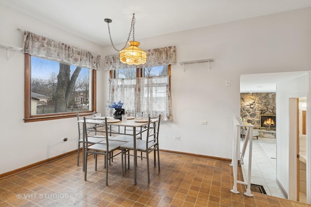 dining area with a fireplace and a wealth of natural light