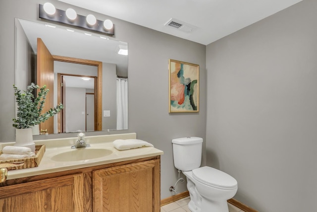 bathroom with toilet, tile patterned floors, and vanity