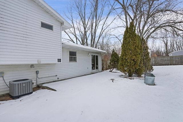 snowy yard featuring central air condition unit