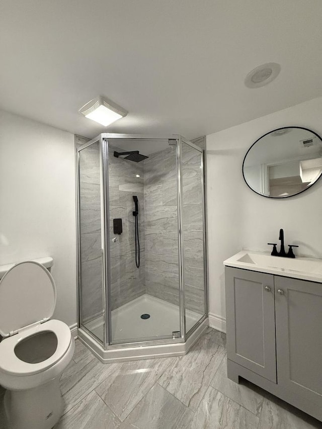 bathroom featuring an enclosed shower, vanity, and toilet