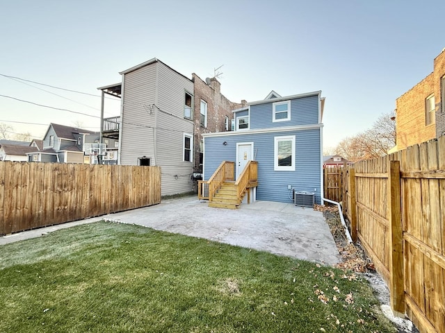 rear view of property featuring central AC, a yard, and a patio