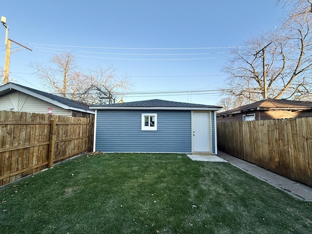 back of property with a yard and an outdoor structure