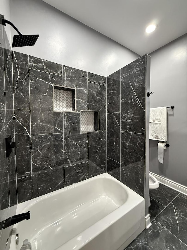 bathroom with tiled shower / bath combo and toilet