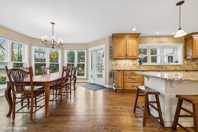 kitchen featuring decorative backsplash, light stone counters, and decorative light fixtures