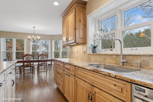 kitchen with sink, dishwasher, light stone countertops, dark hardwood / wood-style flooring, and decorative backsplash