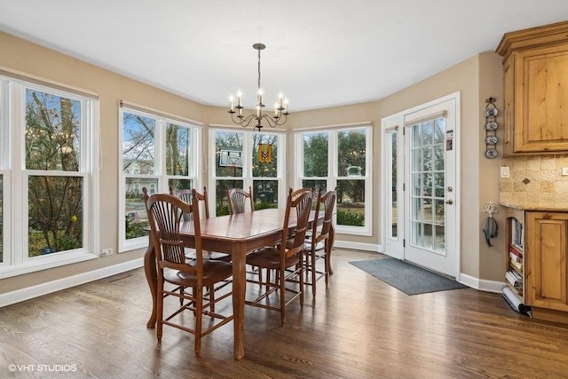 dining area featuring a notable chandelier and dark hardwood / wood-style flooring