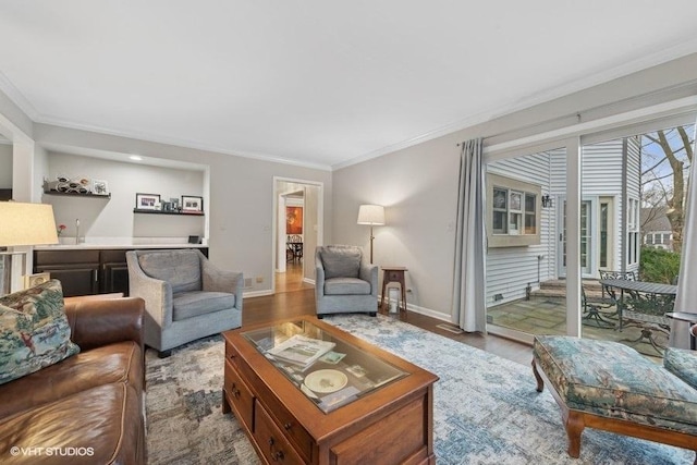 living room featuring crown molding, indoor bar, and light wood-type flooring