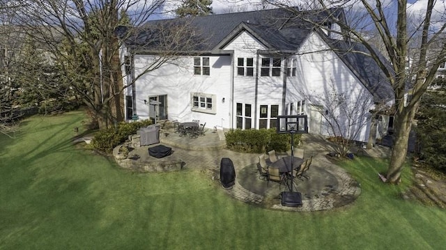 rear view of property with a fire pit, a lawn, and a patio