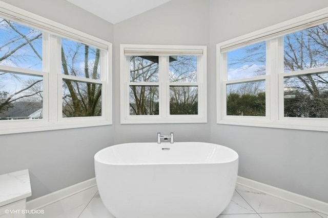 bathroom with lofted ceiling and a bath