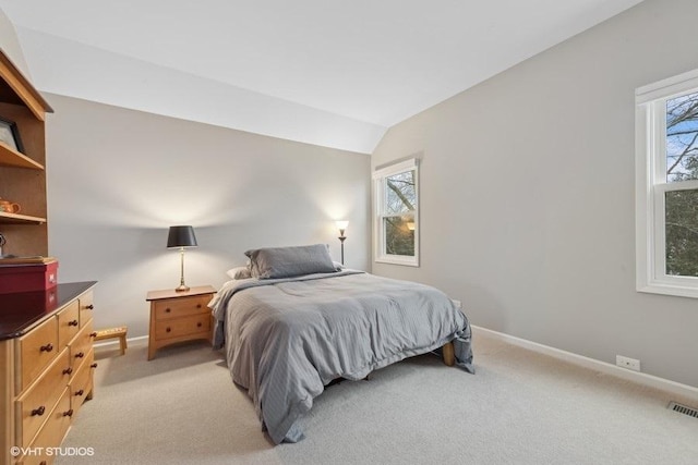 carpeted bedroom with lofted ceiling and multiple windows