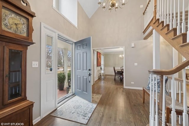 foyer with a high ceiling, dark wood-type flooring, and a chandelier