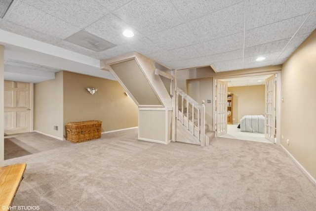 basement with carpet floors and a drop ceiling