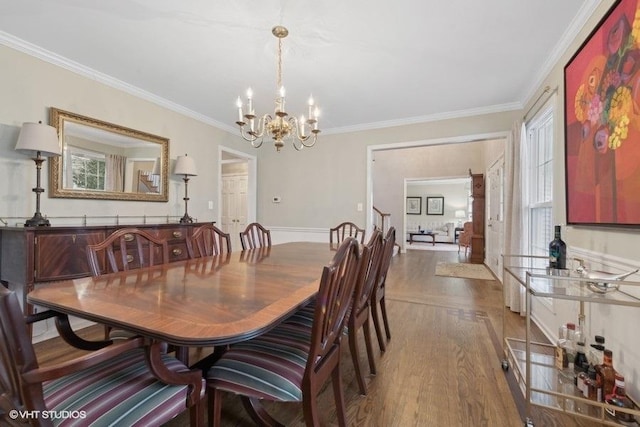 dining space with crown molding, dark hardwood / wood-style floors, and a notable chandelier