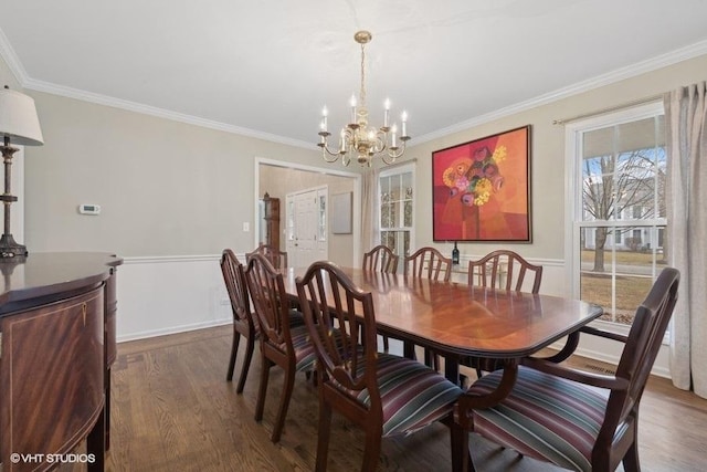 dining space with ornamental molding, an inviting chandelier, and dark hardwood / wood-style flooring