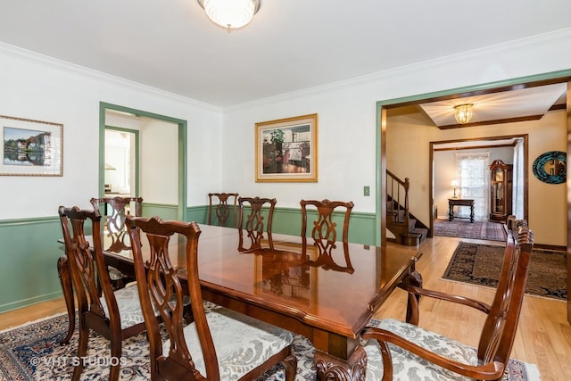 dining space featuring ornamental molding and light hardwood / wood-style floors