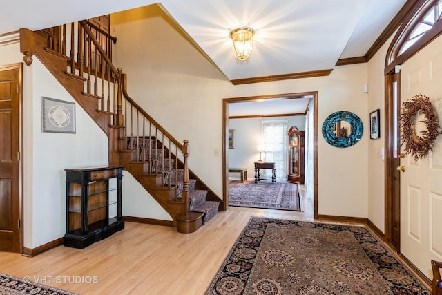 entrance foyer featuring ornamental molding and light hardwood / wood-style flooring