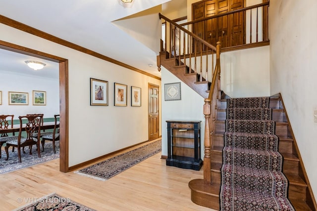 stairway with hardwood / wood-style flooring and ornamental molding