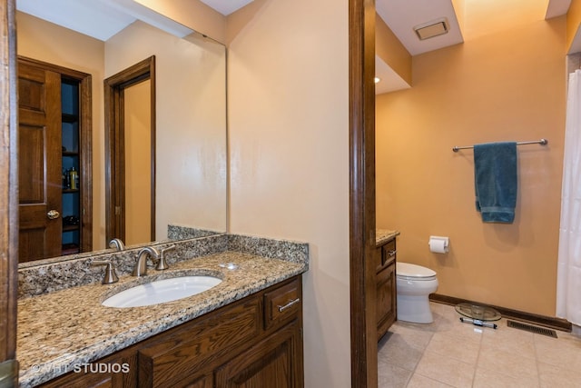 bathroom featuring vanity, tile patterned flooring, and toilet