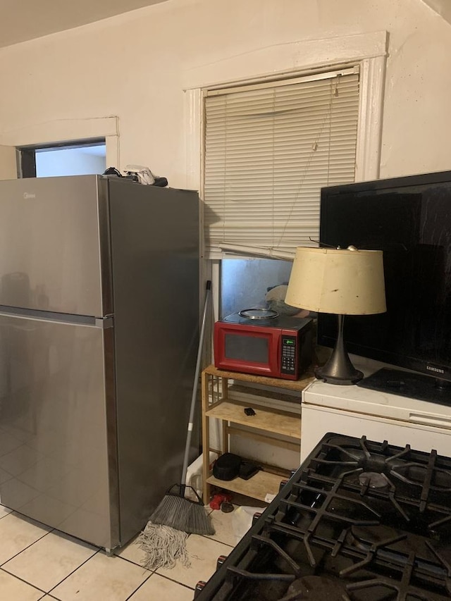 kitchen with stainless steel fridge and light tile patterned flooring