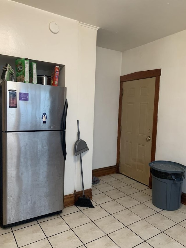 kitchen with light tile patterned floors and stainless steel refrigerator