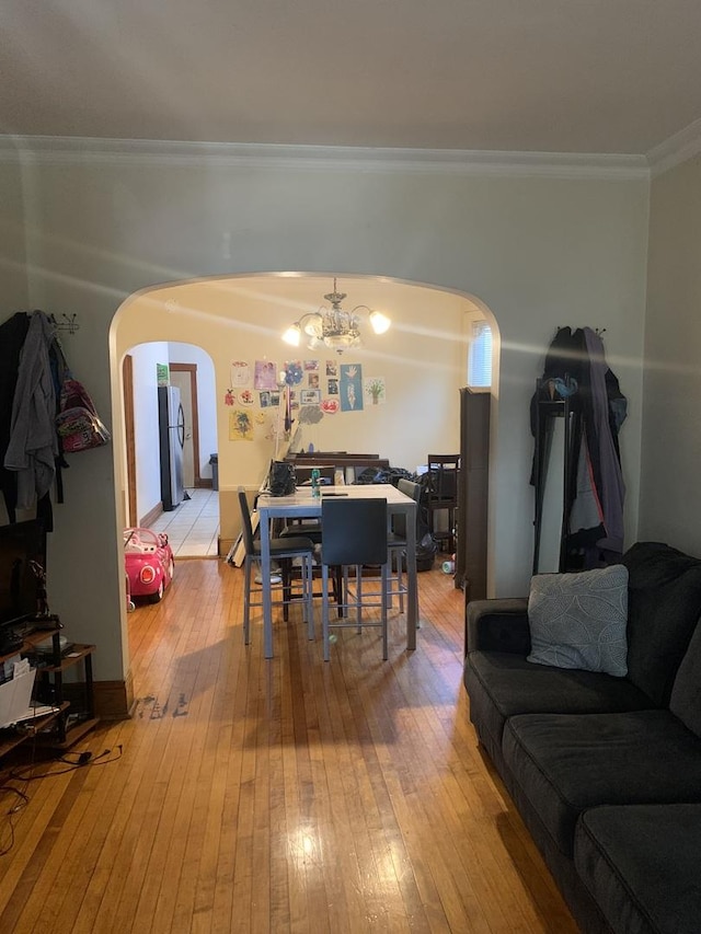 interior space with hardwood / wood-style flooring, crown molding, and a chandelier