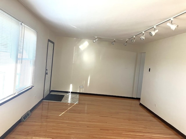 spare room with light hardwood / wood-style floors and a healthy amount of sunlight