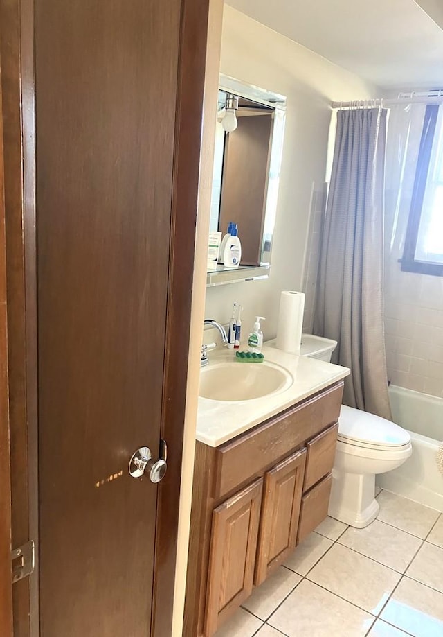 full bathroom with shower / tub combo with curtain, vanity, tile patterned floors, and toilet