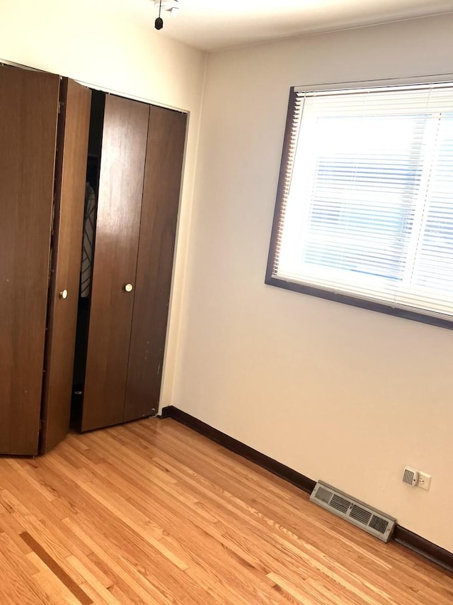 unfurnished bedroom with a closet and light hardwood / wood-style flooring