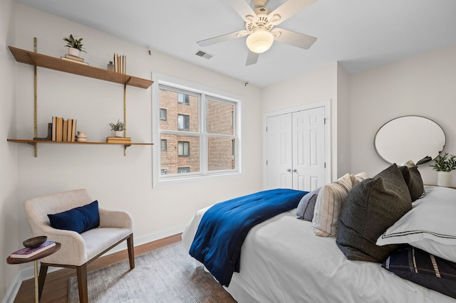 bedroom featuring wood-type flooring, ceiling fan, and a closet