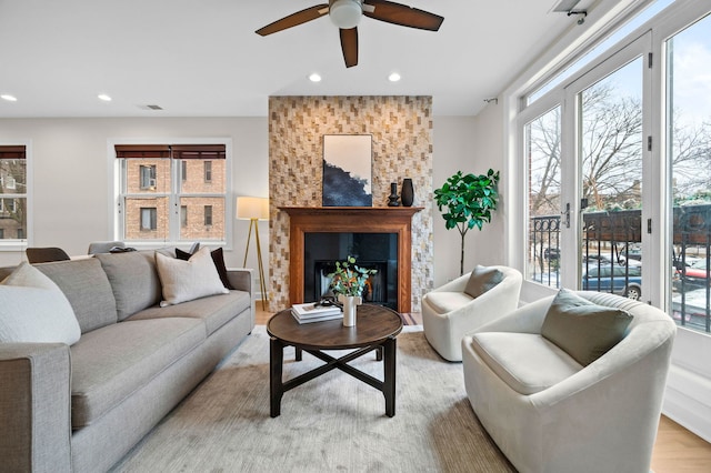 living room with ceiling fan, a healthy amount of sunlight, and light wood-type flooring