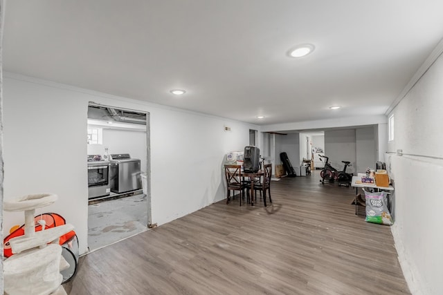 dining area with washer and dryer, wood-type flooring, and ornamental molding