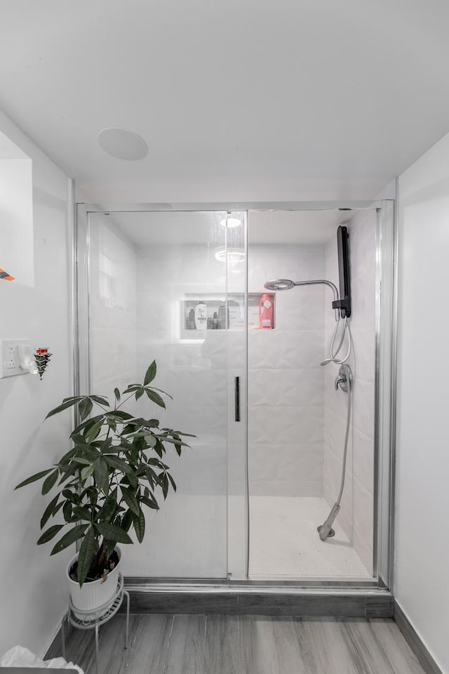 bathroom featuring wood-type flooring and walk in shower