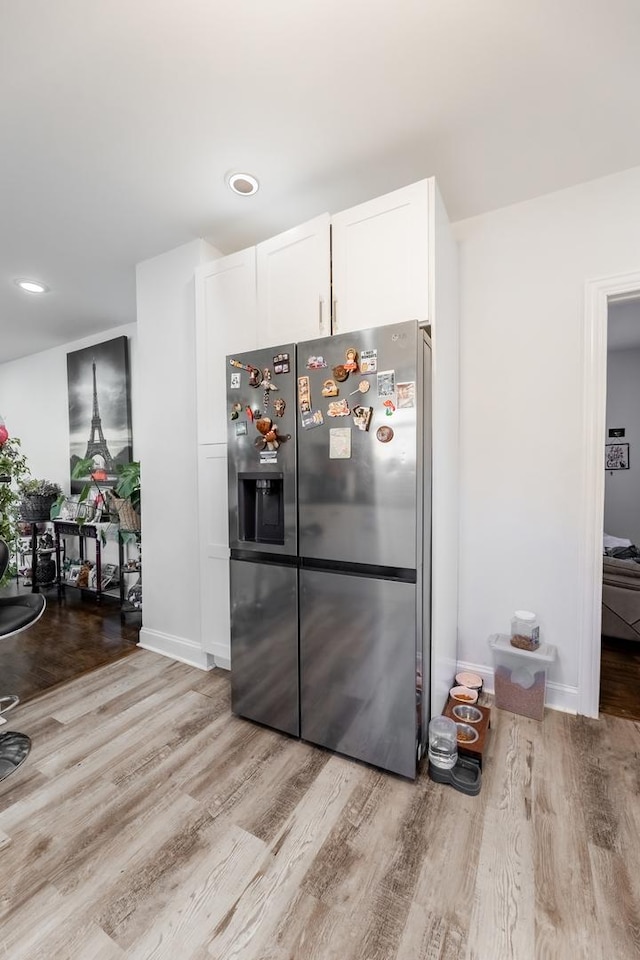 kitchen featuring white cabinets, stainless steel fridge with ice dispenser, and light hardwood / wood-style floors