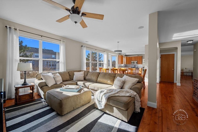 living room with dark wood-type flooring and ceiling fan