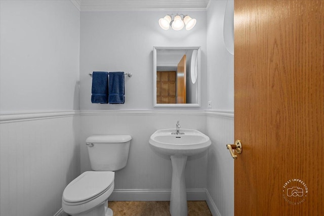 bathroom with ornamental molding and toilet