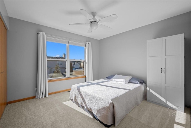 bedroom featuring ceiling fan, light colored carpet, and a closet