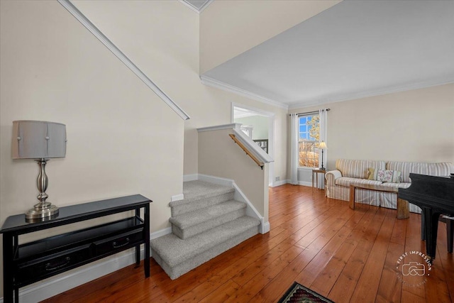 stairs with hardwood / wood-style flooring and crown molding