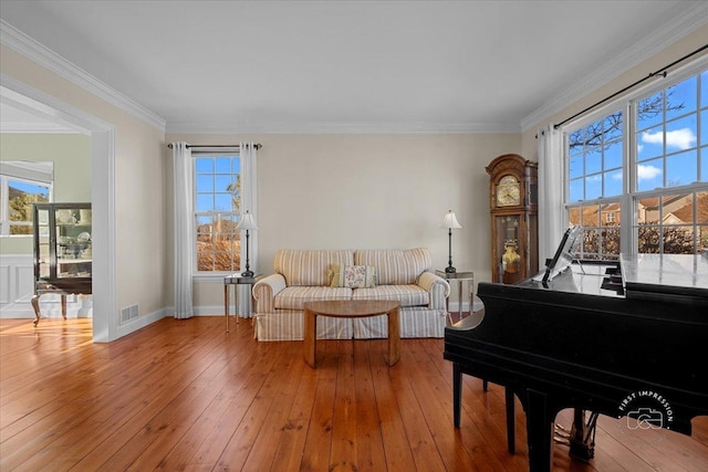 sitting room featuring crown molding, hardwood / wood-style floors, and a wealth of natural light