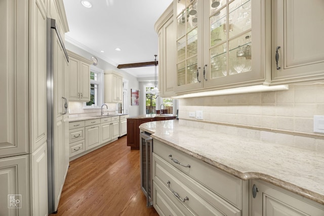 840 Chestnut St, Hinsdale, IL 60521 - kitchen featuring crown molding, a sink, decorative backsplash, glass insert cabinets, and light stone counters
